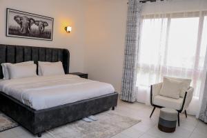 Un dormitorio con una cama grande y una silla. en Sweetwaters Holiday Home Nanyuki, en Nanyuki