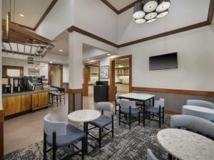 a lobby with tables and chairs and a kitchen at Hyatt Place Tampa Busch Gardens in Tampa