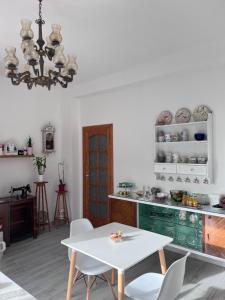a kitchen with a table and chairs and a chandelier at Mencin in Carloforte