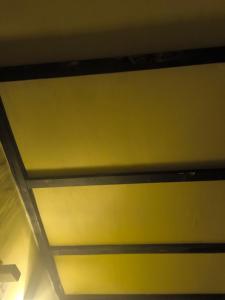 a ceiling in a room with a yellow wall at 我的房间 in Vientiane