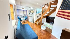 a living room with a blue couch and a staircase at Manhattan Apartment in Romans-sur-Isère
