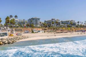 a view of a beach with buildings in the background at Mission Pacific Beach Resort, part of JdV by Hyatt in Oceanside