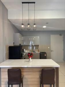 a kitchen with a island with two chairs and a counter top at Trion Residence Kuala Lumpur BY Sky Rainbow in Kuala Lumpur