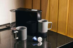 a coffee maker and two cups on a counter at Hilton Kyoto in Kyoto