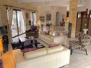 a living room with a white couch and chairs at Villa Asteri, views, private, pool heating on request, 30 mins from Paphos in Paphos