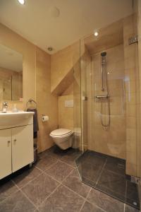 a bathroom with a shower and a toilet and a sink at The Posthoorn Amsterdam in Amsterdam