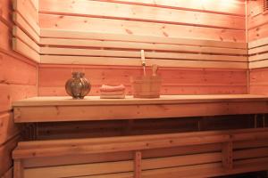 a wooden shelf in a sauna with a candle at Arctic Villa in Kiruna