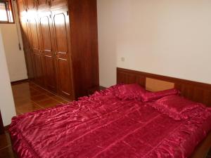 ein Bett mit einer roten Bettdecke in einem Schlafzimmer in der Unterkunft Vila do Conde Holidays Flat in Areia