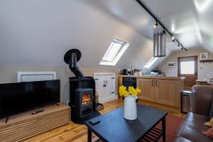 a living room with a fireplace and a stove at Hayloft with Log Burner and panoramic views in Hartington