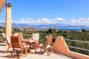 a patio with chairs and a table on a balcony at GrandVillle Cottage Escape with Breathtaking Views in Galatákion