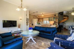 a living room with blue couches and a table at GrandVillle Cottage Escape with Breathtaking Views in Galatákion