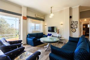 a living room with blue furniture and a table at GrandVillle Cottage Escape with Breathtaking Views in Galatákion +32 photos