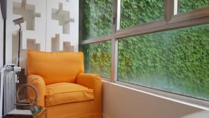 ミラノにあるBnButler - Luxury Apartment - Broletto 39の窓付きのお部屋(オレンジ色の椅子付)