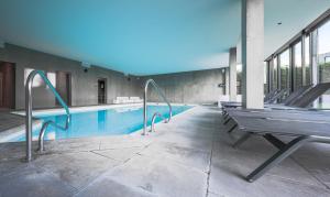 a swimming pool with a bench next to a building at Cosy Cottage Apostroff in Koksijde