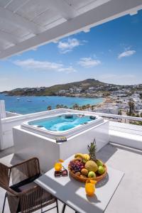 a table with a bowl of fruit and a swimming pool at Deliades Hotel in Ornos
