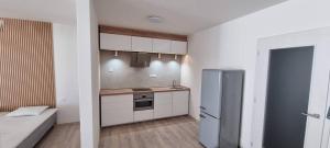 a kitchen with a refrigerator and a couch in a room at Byt v centru Ostravy in Slezská Ostrava