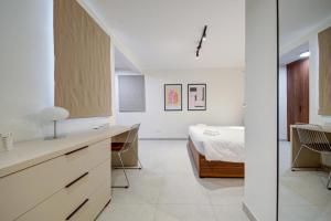 a white room with a bed and a kitchen at Juliet Residence, Apt 4 , Your Home Away from Home in Gzira by SF HOMES in Il-Gżira