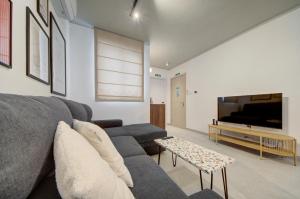 a living room with a couch and a tv at Juliet Residence, Apt 4 , Your Home Away from Home in Gzira by SF HOMES in Il-Gżira