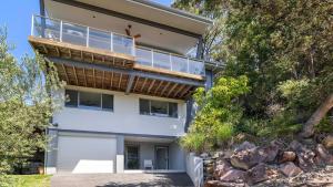 a house with a balcony on the side of it at Hamptons By The Bay in Nelson Bay