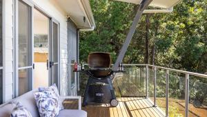 a porch with a chair sitting on a balcony at Hamptons By The Bay in Nelson Bay