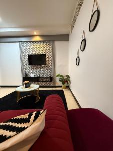 un salon avec un canapé et une télévision dans l'établissement Afripoa Apartments, à Dar es Salaam