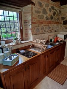 a kitchen with wooden cabinets and a stove top oven at L' antico lavatoio in Radicofani +51 photos