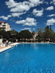 una gran piscina azul con cielo azul en Agata Sunset Studio & Swimming Pool, en Benalmádena