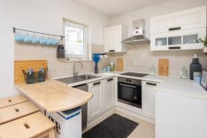 a kitchen with white cabinets and a sink at Apartment GL in Stanići