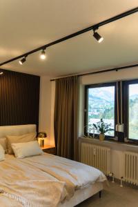 a bedroom with a large bed and a large window at Watzmann Juwel in Berchtesgaden +17 photos