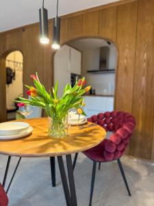 a dining room table with a vase of flowers on it at Watzmann Juwel in Berchtesgaden