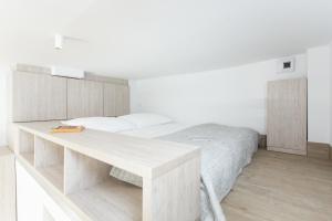 a white bedroom with a bed and a desk at Studio Kampus Garnizon in Gdańsk