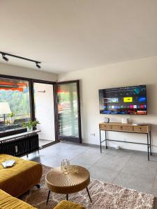a living room with a tv and a couch and a table at Watzmann Juwel in Berchtesgaden