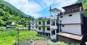 a group of buildings with mountains in the background at Hotel Himalayan in Madheso