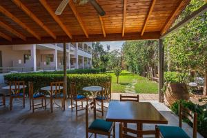 a patio with tables and chairs and a garden at Pantheon Hotel in Rethymno
