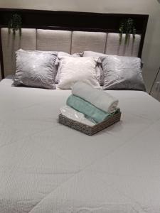 a bed with white pillows and towels on it at 1 bedroom Matina Enclaves in Davao City