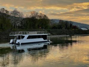 a boat floating on the water at sunset at KL Moselboote - Hausboot Niara in Bernkastel-Kues