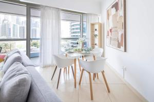 a living room with a couch and a table and chairs at Frank Porter - Saba 3 in Dubai