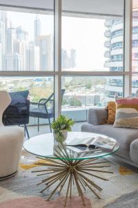 a living room with a glass table and a large window at Frank Porter - Saba 3 in Dubai