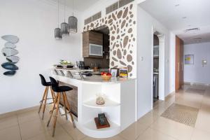 a kitchen with a counter and chairs in a room at Frank Porter - Saba 3 in Dubai