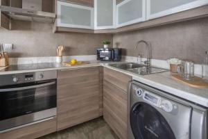 a kitchen with a sink and a washing machine at Frank Porter - Saba 3 in Dubai