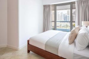a bedroom with a bed and a large window at Frank Porter - Saba 3 in Dubai