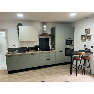 a kitchen with white cabinets and a table and chairs at Studio LOUNA in Vesoul