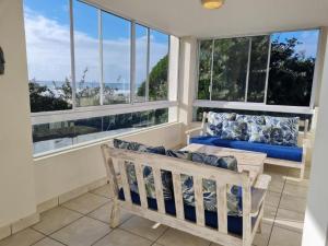 a screened in porch with a bench and windows at Villa 26, Estuary Country Estate, Port Edward, KZN South Coast in Port Edward