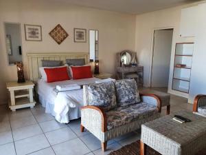 a bedroom with a bed and a couch and a chair at Villa 26, Estuary Country Estate, Port Edward, KZN South Coast in Port Edward +76 photos