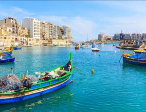 a group of boats in a body of water with buildings at La Bella Guesthouse in St. Julianʼs