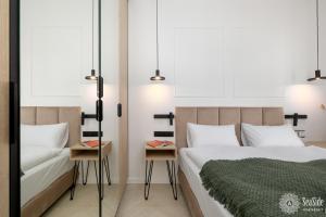 une chambre avec un lit et un canapé dans l'établissement Seaside Apartamenty Ku Morzu Sianożęty 150m to the beach, swimming pool, à Sianożęty 39 autres photos