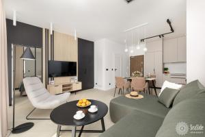 un salon avec un canapé vert et une table dans l'établissement Seaside Apartamenty Ku Morzu Sianożęty 150m to the beach, swimming pool, à Sianożęty