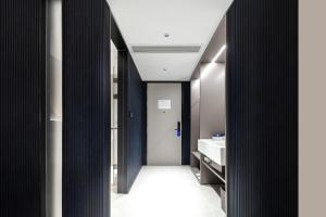 a bathroom with a hallway with a sink and a door at Atour Light Hotel Wuhan Optics Valley Square Subway Station in Wuhan