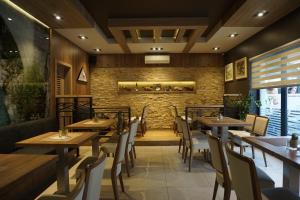 a restaurant with wooden tables and chairs and a brick wall at Rooms and Apartment Soča Kobarid in Kobarid