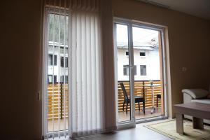 a room with a sliding glass door leading to a balcony at Rooms and Apartment Soča Kobarid in Kobarid +25 photos
